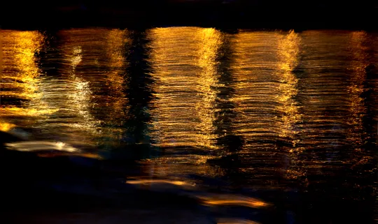 Fadenartige Lichter vor schwarzem Hintergrund