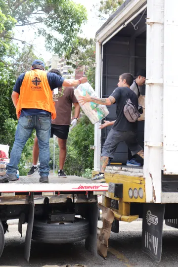 Mitarbeiter von Caritas International beladen einen Lkw mit Hilfsgütern