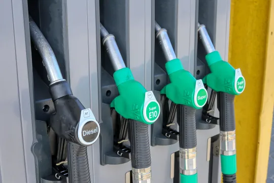 Mehrere Zapfpistolen einer Tankstelle nebeneinander.