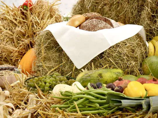 Erntedank-Aufbau aus Strohballen, frischem Obst, Gemüse und Brot