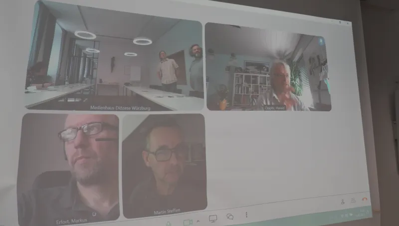 Videokonferenz mit mehreren Teilnehmern in getrennten Fenstern auf einem Bildschirm.